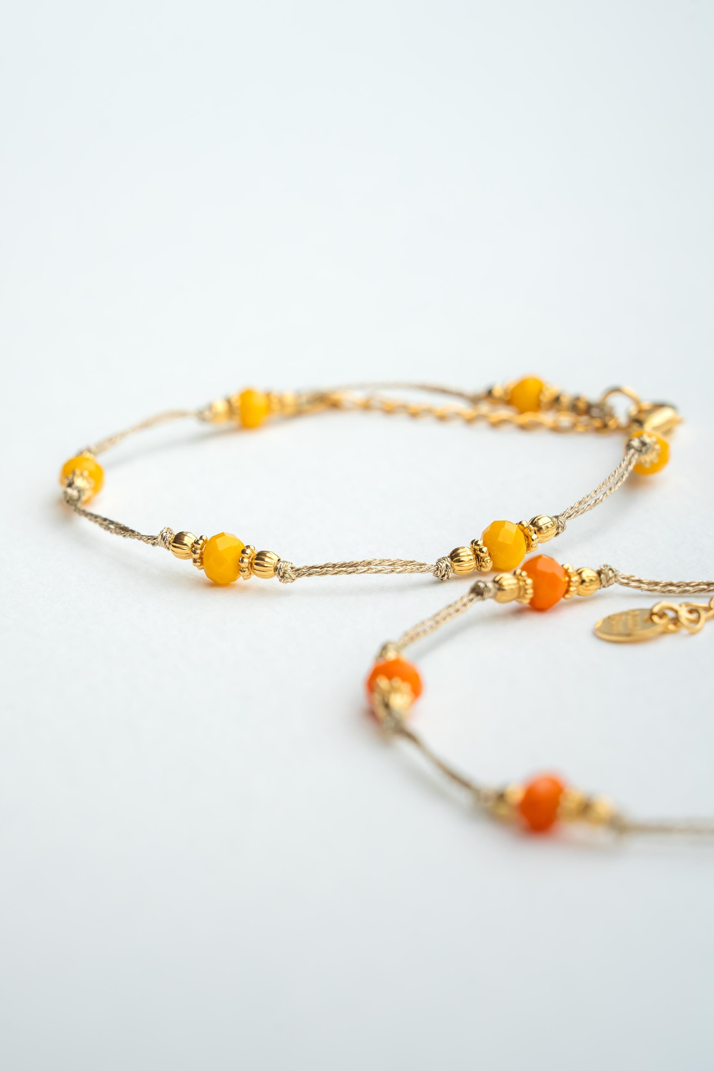 Bracelet en fil métallisé doré avec perles orange ou jaune et éclats d’or fin Byciclou