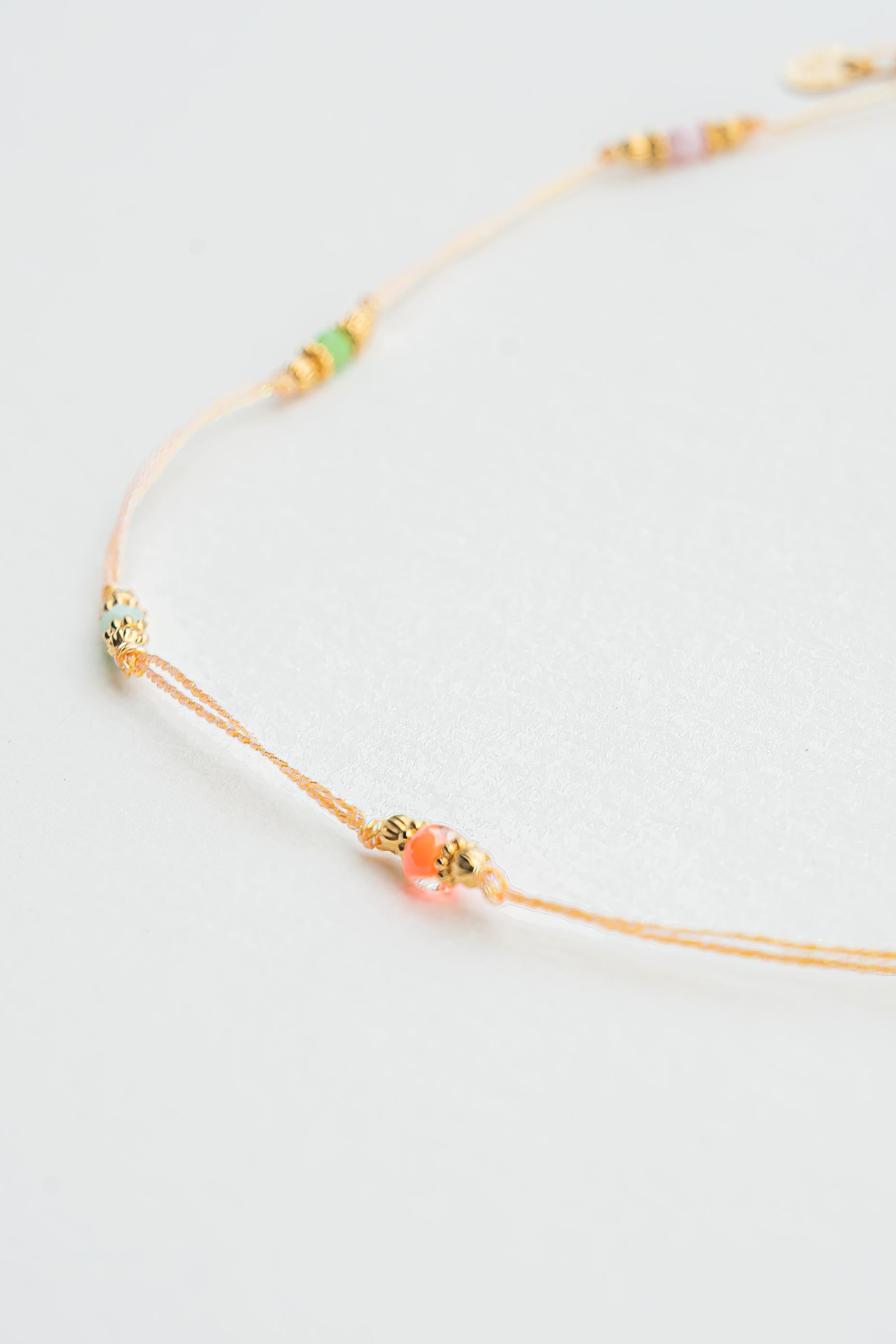 Collier ras de cou en fil métallisé corail avec perles colorées et détails dorés à l’or fin Byciclou