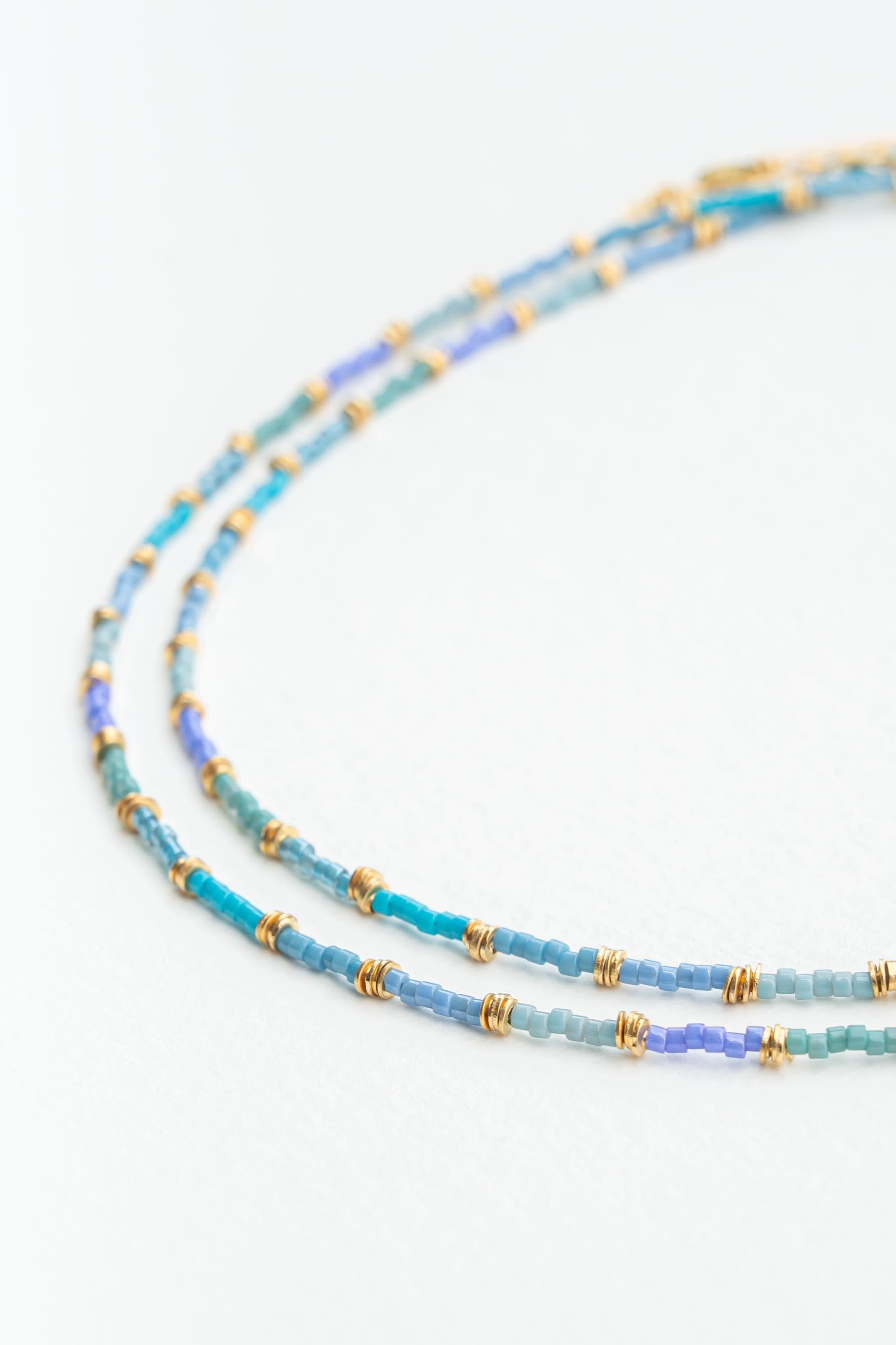 Collier ras de cou en perles japonaises bleu avec perles Heishi dorées à l’or fin Byciclou