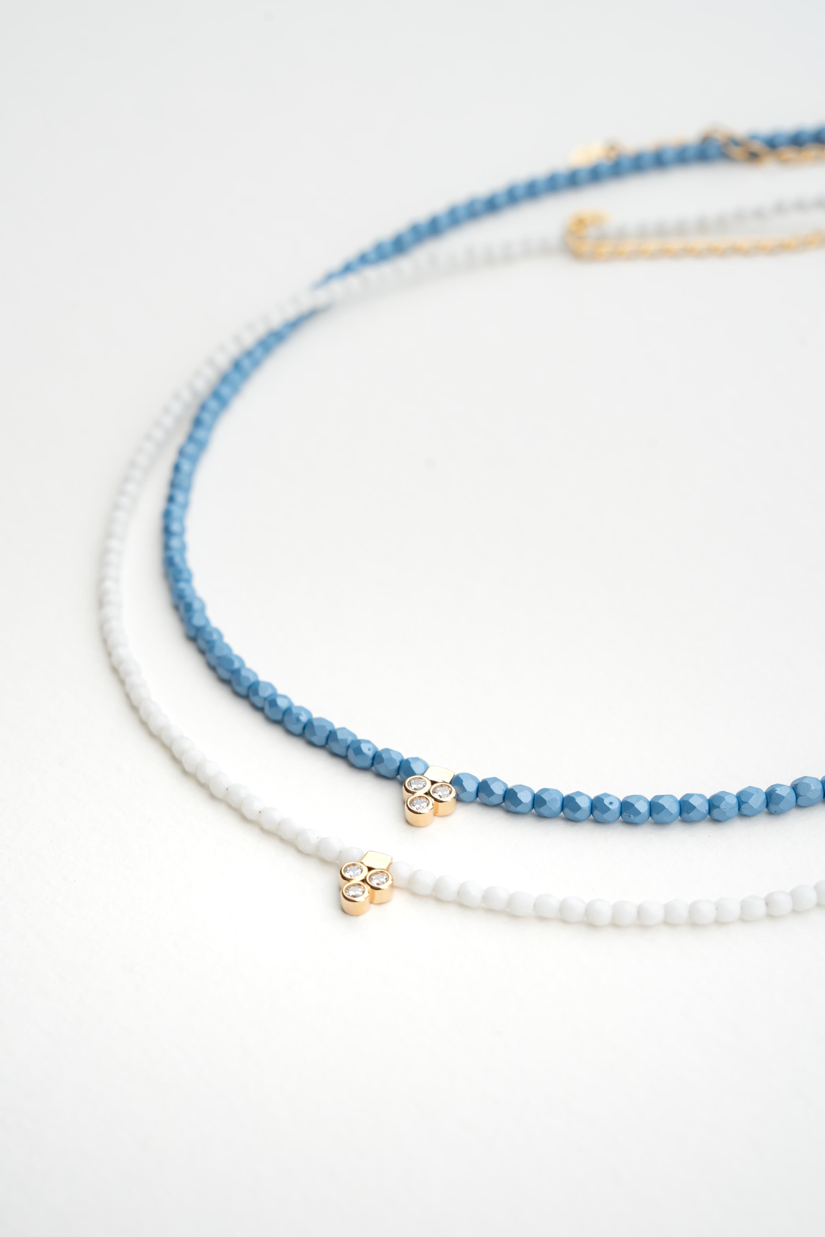 Collier ras de cou en perles de bohème bleu avec pendentif doré serti de trois brillants Byciclou